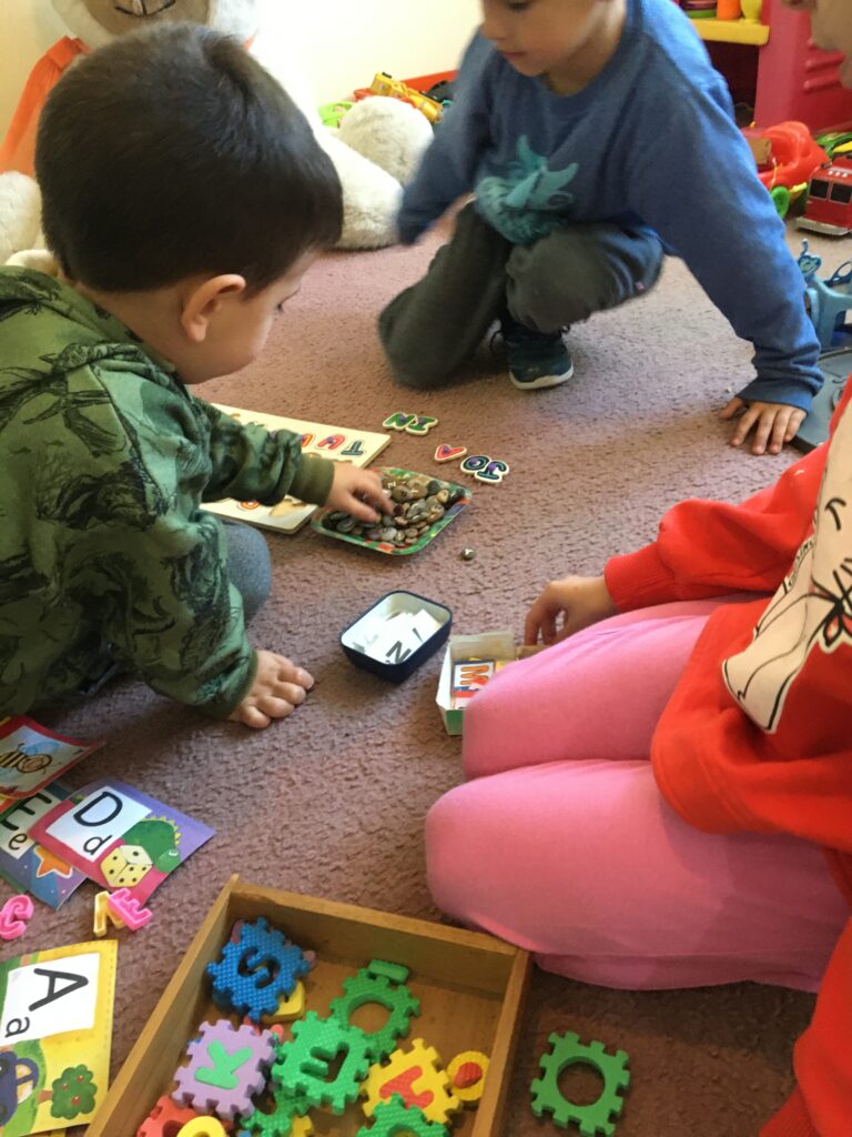 Niños jugando con letras en un espacio agradable.